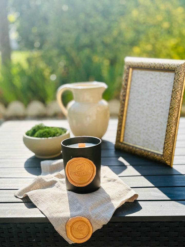 Objets de décoration vintage de seconde main avec cruche en gres, cadre baroque et bougie artisanale. 